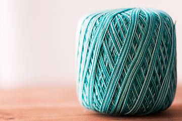 Image showing ball of turquoise cotton yarn on wood