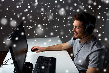 Image showing man in headset playing computer video game at home