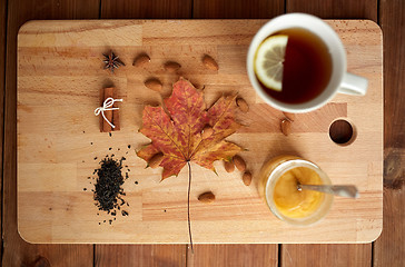 Image showing cup of lemon tea and honey on wooden board