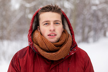 Image showing happy man in winter jacket with hood outdoors