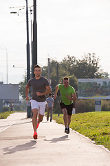 Image showing Two young men jogging through the city