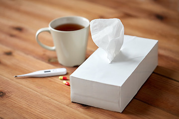 Image showing cup of tea, paper wipes and thermometer with pills