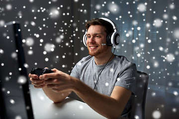 Image showing man in headset playing computer video game at home