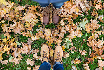 Image showing couple of feet in boots and autumn leaves