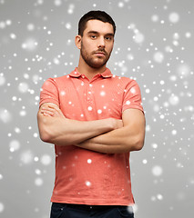 Image showing young man with crossed arms over snow