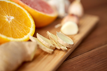 Image showing ginger, garlic and orange on wooden board