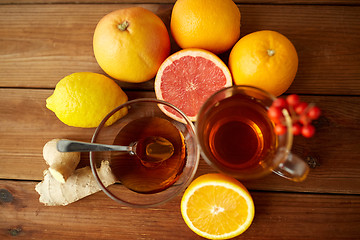 Image showing ginger tea with honey, citrus and garlic on wood