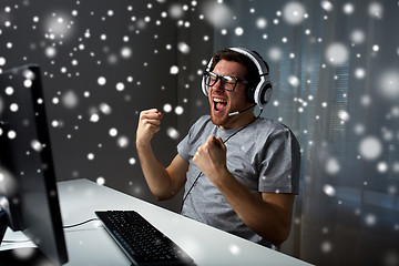 Image showing man in headset playing computer video game at home