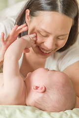 Image showing Mixed Race Chinese and Caucasian Baby Boy In Bed with His Mother