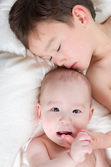 Image showing Mixed Race Chinese and Caucasian Baby Brothers Having Fun Laying