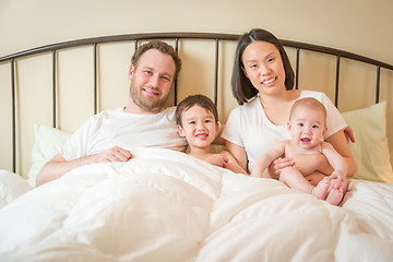 Image showing Mixed Race Chinese and Caucasian Baby Boys Laying In Bed with Th