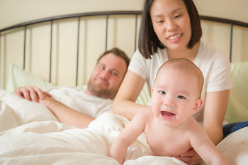 Image showing Chinese and Caucasian Baby Boy Laying In Bed with His Parents