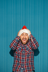 Image showing Surprised christmas man wearing a santa hat