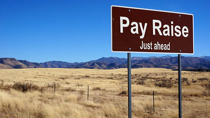 Image showing Pay Raise brown road sign