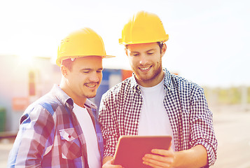 Image showing smiling builders in hardhats with tablet pc