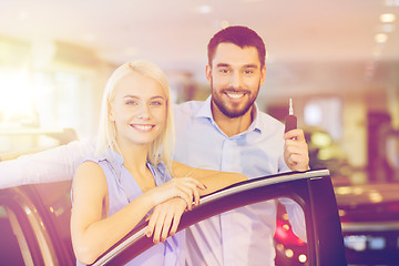 Image showing happy couple buying car in auto show or salon