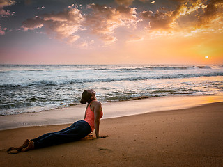 Image showing Woman practices yoga asana Urdhva Mukha Svanasana at the beach