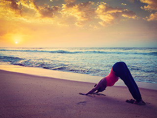 Image showing Young sporty fit woman doing yoga at beach on sunset