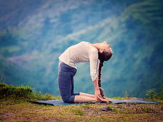 Image showing Woman doing yoga asana Ustrasana camel pose outdoors