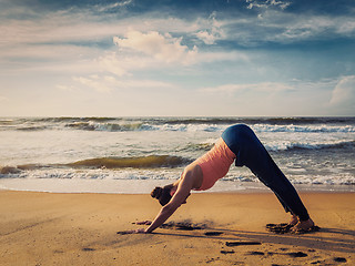 Image showing Young sporty fit woman doing yoga oudoors at tropical beach