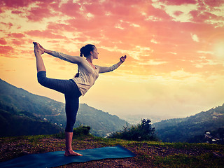 Image showing Woman doing yoga asana Natarajasana outdoors at waterfall