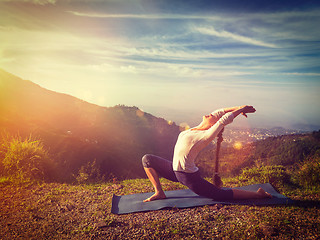 Image showing Sporty fit woman practices yoga Anjaneyasana in mountains