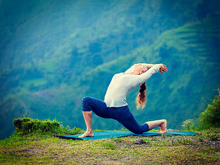 Image showing Sporty fit woman practices yoga asana Anjaneyasana in mountains