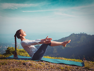 Image showing Woman doing Ashtanga Vinyasa Yoga asana Navasana - boat pose