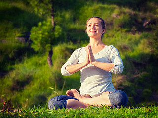 Image showing Young sporty fit woman doing yoga Lotus pose oudoors 