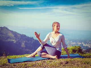 Image showing Woman doing Ardha matsyendrasana asana outdoors