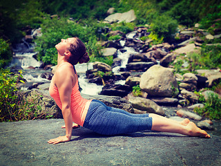 Image showing Woman practices yoga asana Urdhva Mukha Svanasana outdoors