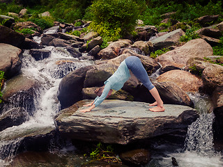 Image showing Young sporty fit woman doing yoga oudoors at tropical waterfall