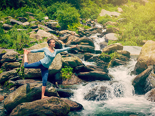 Image showing Woman doing yoga asana Natarajasana outdoors at waterfall