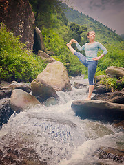 Image showing Woman doing Ashtanga Vinyasa Yoga asana outdoors at waterfall