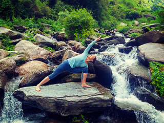 Image showing Woman practices yoga asana Utthita Parsvakonasana outdoors