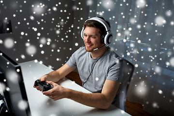 Image showing man in headset playing computer video game at home