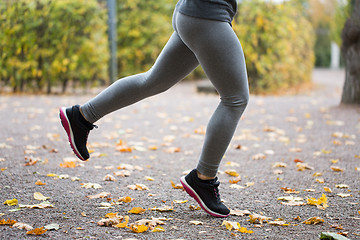 Image showing close up of young woman running in autumn park