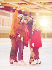 Image showing happy friends taking selfie on skating rink