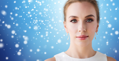 Image showing face of beautiful woman in white over snow