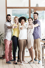 Image showing happy creative team showing thumbs up in office