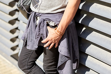 Image showing close up of man with bag standing at wall