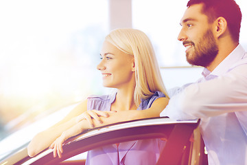 Image showing happy couple buying car in auto show or salon