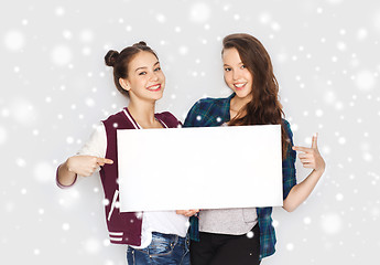 Image showing smiling teenage girls holding white blank board