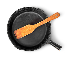 Image showing Old cast iron pan with wooden spatula top view