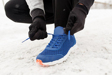 Image showing close up of man tying shoe lace in winter outdoors