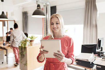 Image showing happy creative female office worker with tablet pc