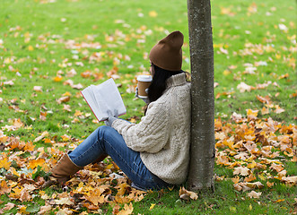 Image showing woman with book drinking coffee in autumn park