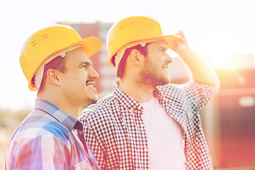 Image showing group of smiling builders in hardhats outdoors