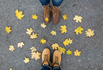Image showing couple of feet in boots and autumn leaves