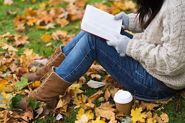 Image showing woman with book drinking coffee in autumn park